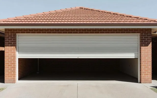 A white roller door on a brick-and-tile home